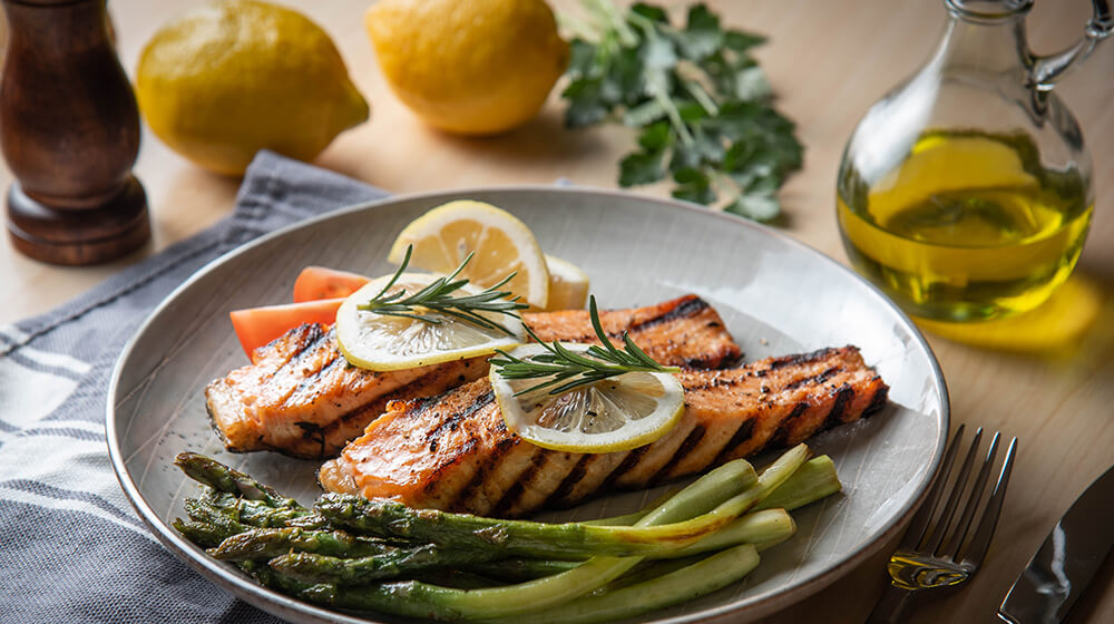 Delicious looking salmon dinner on clean plate with side of asparagus