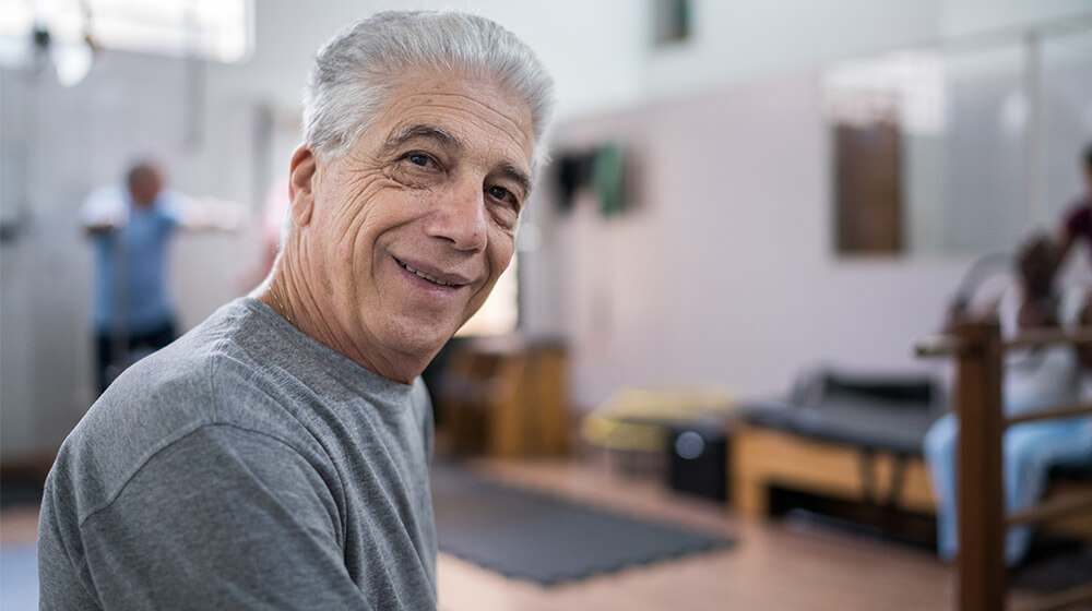 Man in exercise room smiles and gets ready to work out
