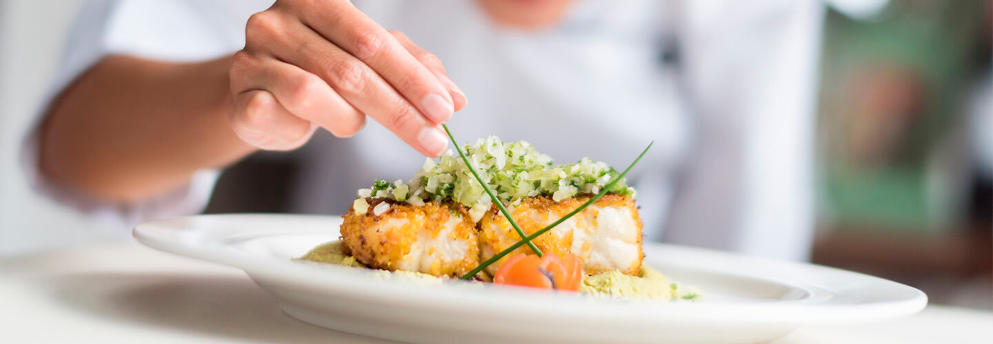 Chef adds garnish to seafood plate